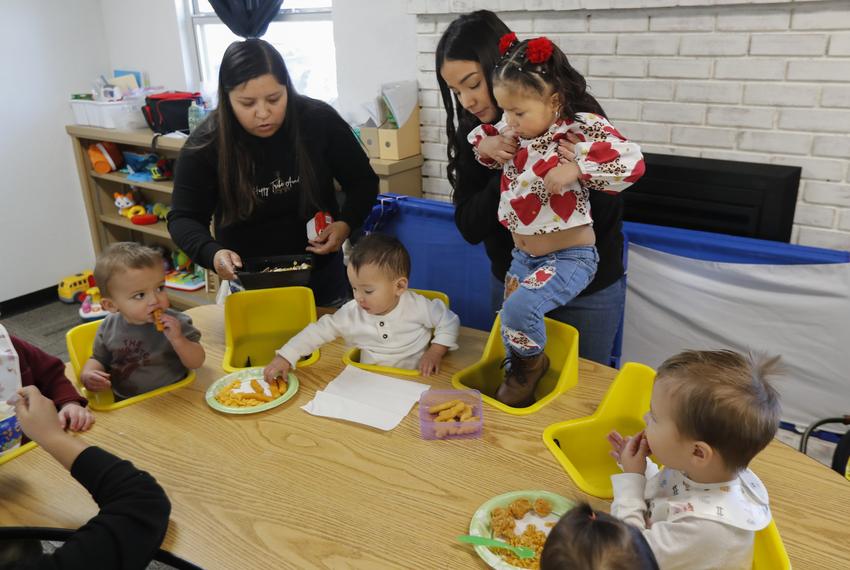 Mariza Licerio, Director of Happy Tribe Academy daycare, puts one of her daycare kids in a seat to eat lunch Wednesday, Jan. 10, 2024, in Friona. 