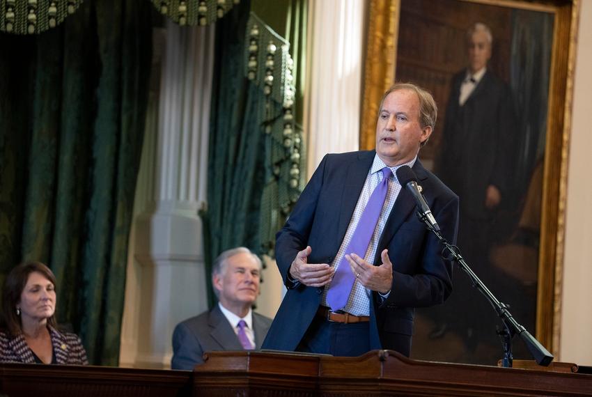 Texas Attorney General Ken Paxton speaks to his supporters after being sworn into office on January 10, 2023.  At left are state Sen. Angela Paxton and Gov. Greg Abbott.