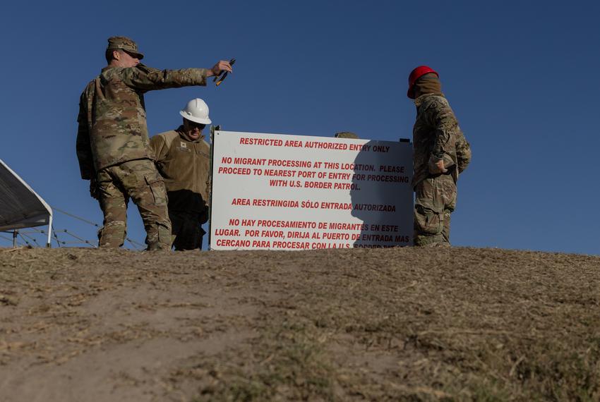 Texas National Guard members install a sign, meant to detract migrants from crossing the Rio Grande, at the bank of the river in Eagle Pass, on Jan. 17, 2024.