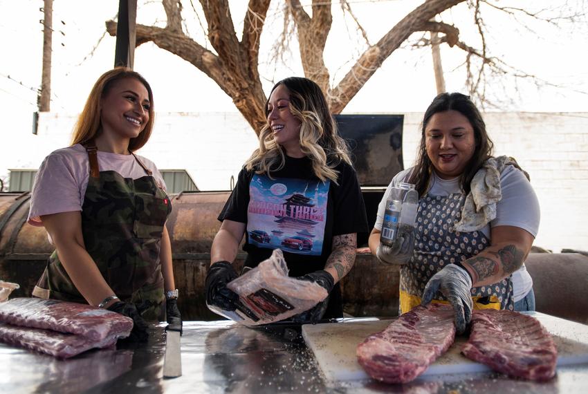 Raquel Lopez, left, Simone See, center, and Jewel Hill, right, season ribs before putting them on the smoker at Hill Barbecue Friday, Feb. 9, 2024, in Lubbock, Texas. (Justin Rex for The Texas Tribune)