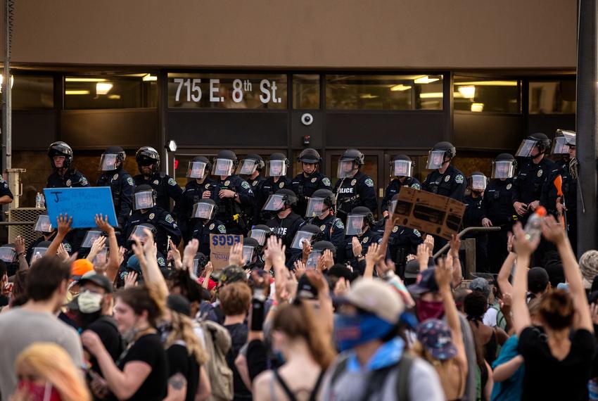 A crowd raises their hands in protest in front of the Austin Police Department's headquarters in downtown Austin during the George Floyd and Michael Ramos protests on May 31, 2020.