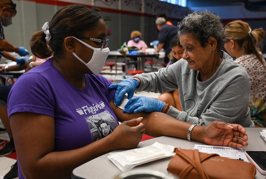 Barbara Edmonds, right, practices applying pressure on a wound on Deborah Berry during a CERT training at Felix Cook, Jr. Elementary School in Houston on August 1, 2022.