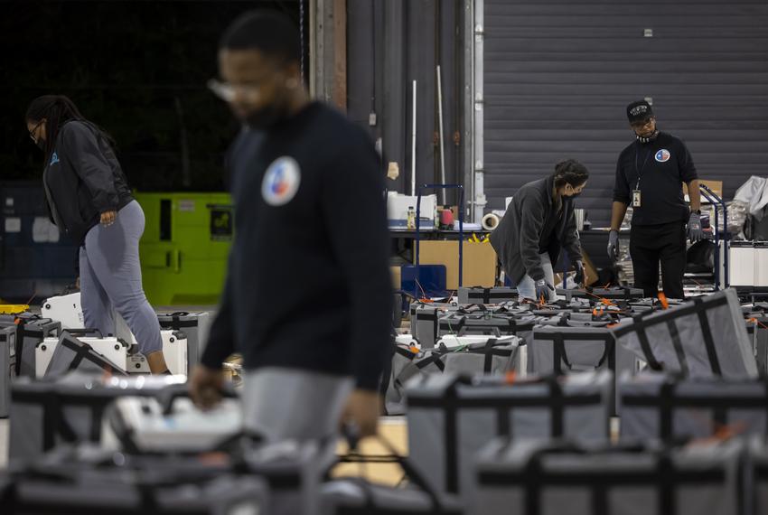 Harris County Elections Staff members carry in and sort ballot bags at the Elections Technology Center in northwest Houston on Tuesday, March 1, 2022.