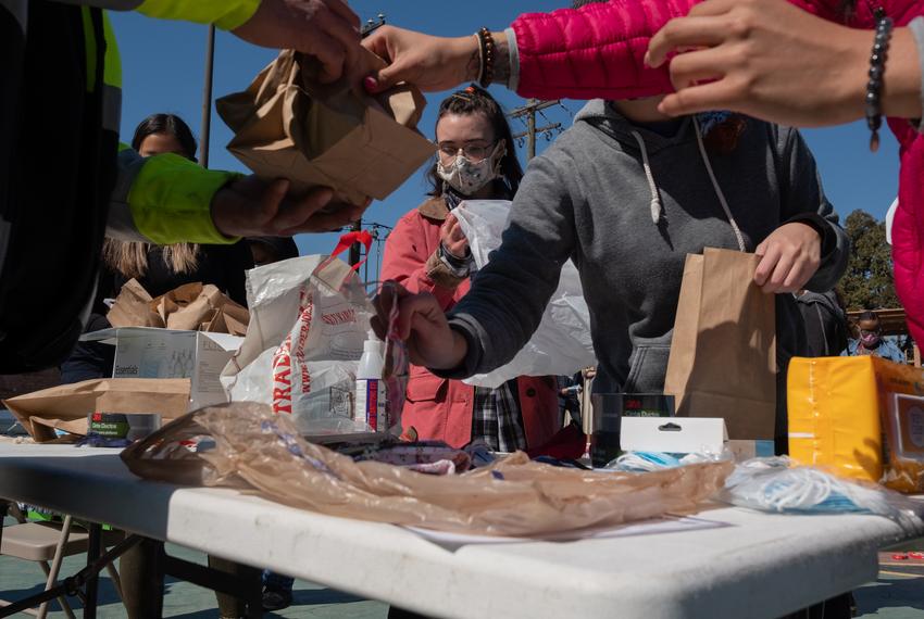 Volunteer Kaede Polkinghorne, center, helps a team of volunteers prepare masks at Kelly Garden at a supply distribution event on Feb. 19, 2021 in Houston. Many in Houston are still without water or supplies in the aftermath of the statewide snowfall. (May-Ying Lam for The Texas Tribune) KAEDE – white female