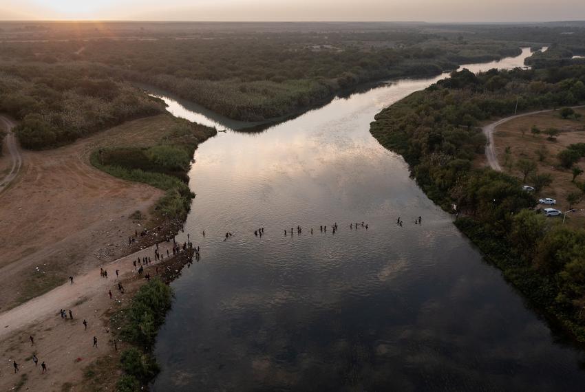 Migrants seeking refuge in the U.S. cross the Rio Grande, bags and children in tow, back into Ciudad Acuña, Tamaulipas, Mexico from their camp in Del Rio on Sept. 21, 2021.