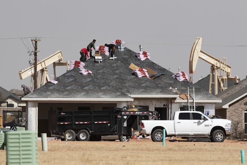 A roofing crew begins to shingle a home under construction in the new Pavilion Park housing development in North Midland Monday, March 14, 2022.