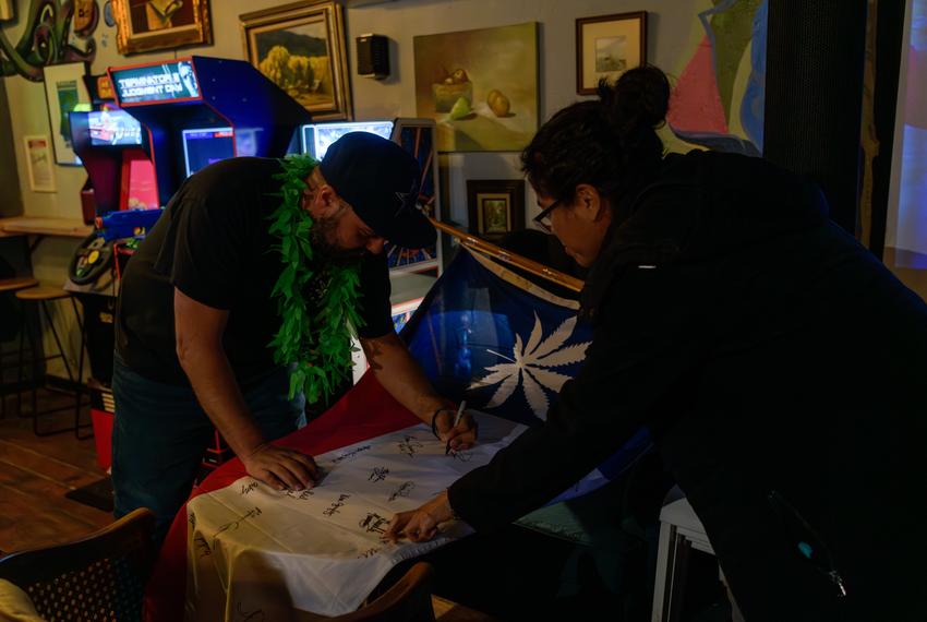 Supporters of the Freedom Act Lubbock sign a flag showing their solidarity with Prop A at a watch party on May 4, 2024.