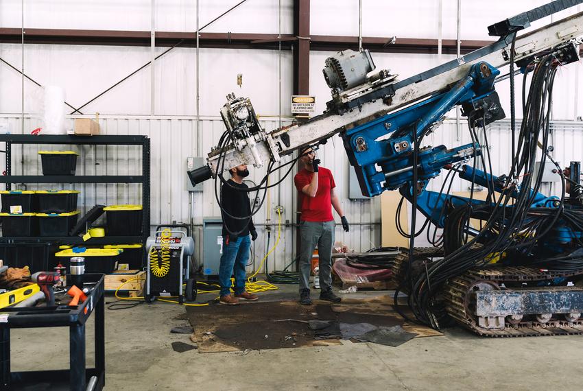 Employees of Quaise Energy stand next to a repurposed drilling rig that will hold a wave guide in Houston, on Thursday, Feb. 15, 2024. (Joseph Bui for The Texas Tribune)