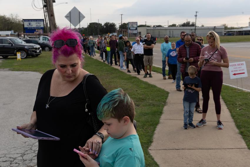 Eliza Smarr and her son Mason, 8, wait in line to cast their ballots on Election Day at the Blue Mound City Hall in Blue Mound on November 8, 2022.